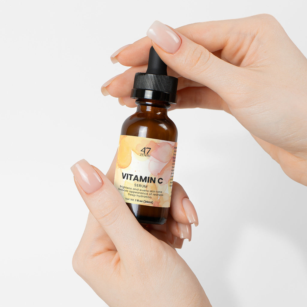 Hand holding a bottle of Elysera Vitamin C Serum against a white background