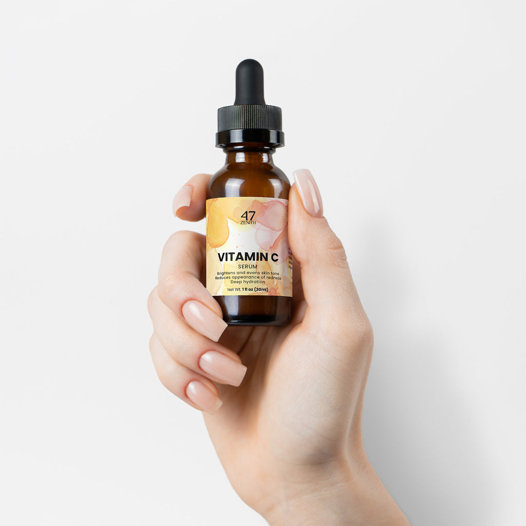 Hand holding a bottle of scalp health and hair growth oil with a white background